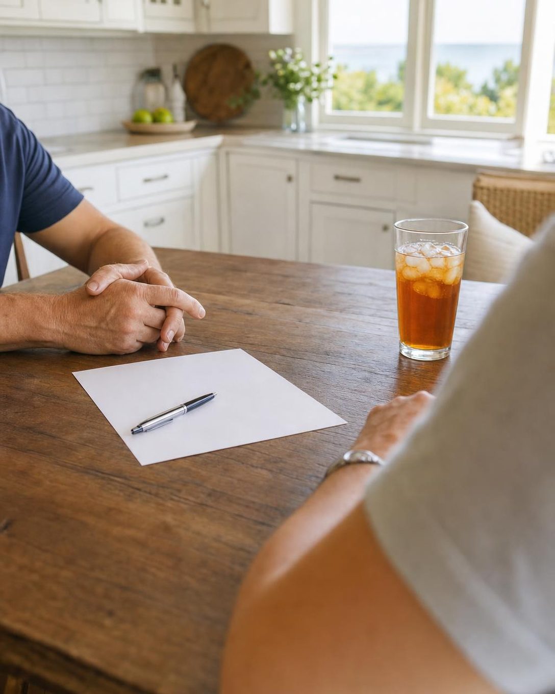 A home buyer reviewing paperwork with a couple at their kitchen table